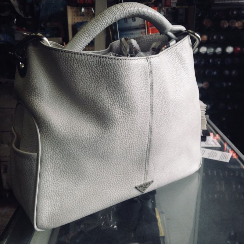 A gray suede handbag after cleaning and repair